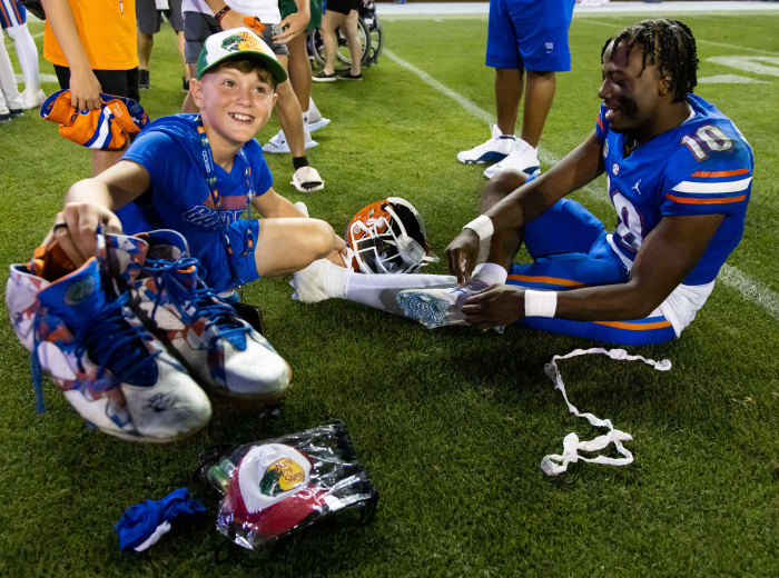 Florida Gators fan holds up autographed cleats.